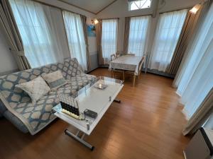 ein Wohnzimmer mit einem Sofa und einem Tisch in der Unterkunft オーシャンリゾートshimaoドリームbeach in Himi