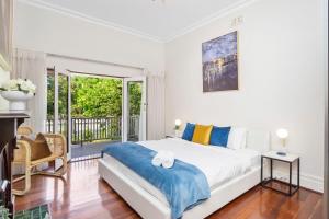 a bedroom with a large bed and a balcony at Hyde Park Vista Spacious 3br Home in Perth