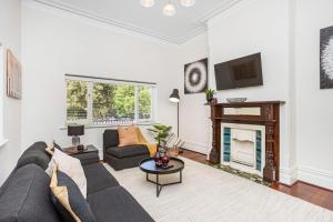 a living room with a couch and a fireplace at Hyde Park Vista Spacious 3br Home in Perth