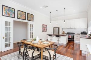 a kitchen and dining room with a wooden table and chairs at Hyde Park Vista Spacious 3br Home in Perth