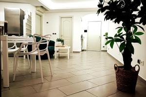 ナポリにあるBORGO LORETO NAPLESのダイニングルーム(テーブル、椅子、鉢植えの植物付)