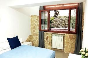 een slaapkamer met een blauw bed en een raam bij BORGO LORETO NAPLES in Napels