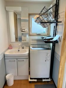 ein kleines Bad mit einem Waschbecken und einem Spiegel in der Unterkunft オーシャンリゾートshimaoドリームbeach in Himi