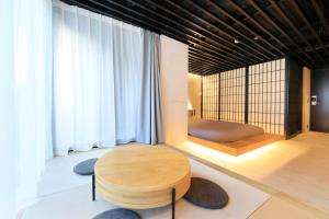 a living room with a wooden table and a couch at Amanecer Hotel in Tokyo