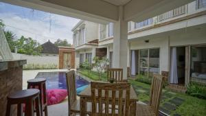 登巴薩的住宿－Maharani Residence，一个带桌椅的庭院和一个游泳池