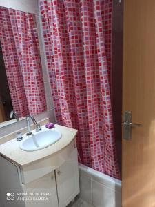 baño con lavabo y cortina de ducha roja en Recoleta Unique agüero apartments en Buenos Aires