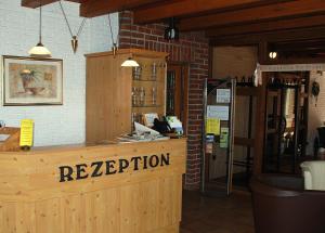 a restaurant with a reception desk in a room at Alter Dorfkrug Am Kanal in Wolfsburg