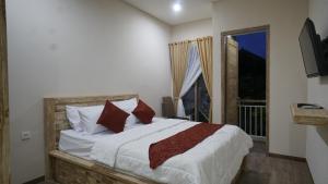 sypialnia z dużym łóżkiem i oknem w obiekcie Maharani Residence w mieście Denpasar
