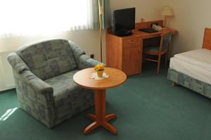 a room with a couch and a table in a hotel room at Alter Dorfkrug Am Kanal in Wolfsburg