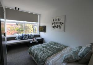 a bedroom with a bed and a window at Beach Road Hotel in Sydney