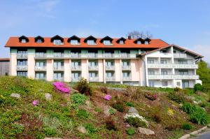 ein Gebäude auf einem Hügel mit Blumen davor in der Unterkunft Hotel Landgasthof Hohenauer Hof in Hohenau