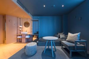 东京toggle hotel suidobashi TOKYO的蓝色的客房配有床、桌子和椅子