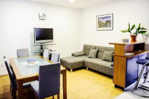 ein Wohnzimmer mit einem Sofa und einem Tisch in der Unterkunft Apartments Slava Petricevic in Podstrana