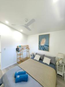 um quarto com uma cama grande e almofadas azuis em Lovely Hidden Gem in Redcliffe em Redcliffe