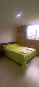 a large green bed in a room with a window at Apartamento relajante , exclusivo, moderno e iluminado ,Sabaneta ,Medellín in Sabaneta