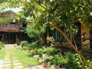 a house with a garden in front of it at Pinaluyan Guest House in Puerto Princesa City
