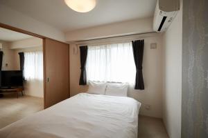 Postel nebo postele na pokoji v ubytování New Normal Hotel in NAGO ニューノーマルホテルイン名護