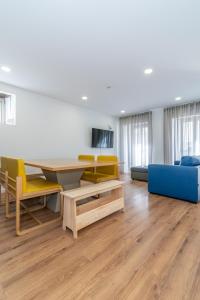 a living room with a table and chairs and a couch at Dude Beach Hostel in Figueira da Foz