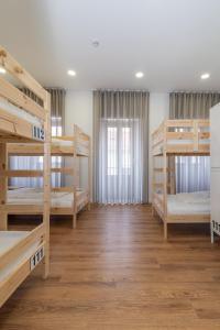 a room with four bunk beds and a window at Dude Beach Hostel in Figueira da Foz