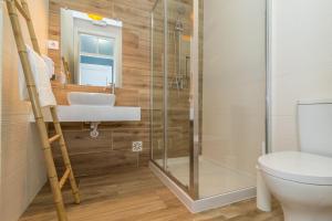 a bathroom with a shower and a sink and a toilet at Dude Beach Hostel in Figueira da Foz