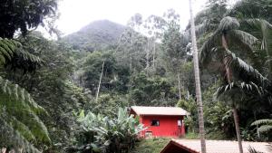 a red house in the middle of a mountain at POUSADA CHALÉS DA GROTA de SÃO PEDRO DA SERRA- NOVA FRIBURGO in Nova Friburgo
