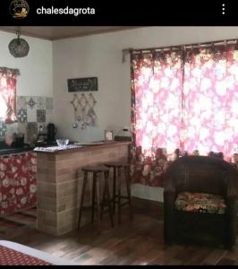 a kitchen with a counter and a bar in a room at POUSADA CHALÉS DA GROTA de SÃO PEDRO DA SERRA- NOVA FRIBURGO in Nova Friburgo