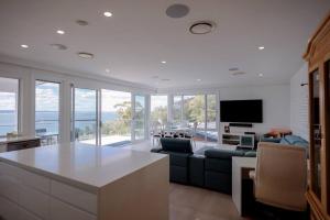 a kitchen and living room with a view of the ocean at Spectacular water views & entertaining spaces in Corlette