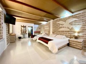 a bedroom with two beds and a brick wall at Casa de Sal - Salt Hotel in Uyuni