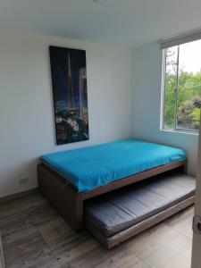 a bed sitting in a room with a window at Maravilloso Apartamento Girardot Ricaurte con vista Panorámica in Ricaurte