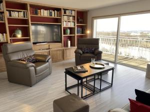 a living room with two chairs and a television at Appartement panoramique au centre de Moulins avec terrasse, 2 chambres, et équipements modernes - FR-1-489-412 in Moulins