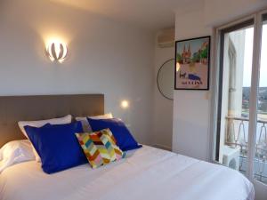 a bedroom with a bed with blue pillows and a window at Appartement panoramique au centre de Moulins avec terrasse, 2 chambres, et équipements modernes - FR-1-489-412 in Moulins
