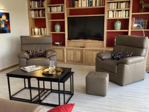 salon z 2 krzesłami i telewizorem w obiekcie Appartement lumineux à Moulins avec terrasse et proche centre - FR-1-489-413 w mieście Moulins