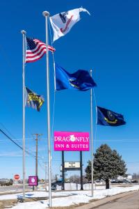 a group of flags on a pole with a sign at Dragonfly Inn & Suites in Hastings