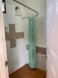 y baño con ducha con cortina verde. en ANGEL RESORT i, en Amphoe Sawang Daen Din
