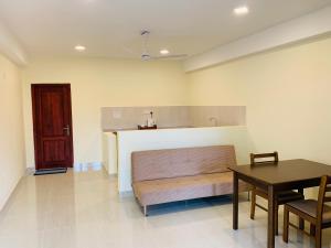 Zimmer mit einer Bank, einem Tisch und einer Tür in der Unterkunft Hotel EliteInn Mahiyanganaya in Mahiyangana