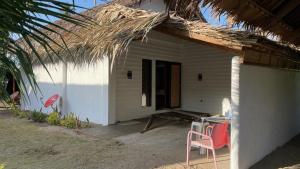 una pequeña casa blanca con una silla y una mesa en Footprints Beach Resort en Agpudlos