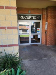 an open door of a building with a evacuation sign at Jetty Blue Backpackers in Coffs Harbour