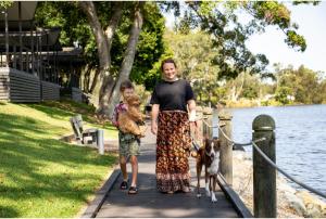 a man and a child walking a dog on a leash at Discovery Parks - Forster in Tuncurry