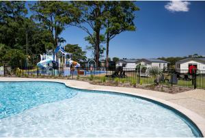 uma piscina num parque com parque infantil em Discovery Parks - Forster em Tuncurry