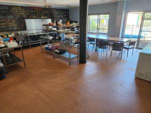Jetty Blue Backpackers في كوفس هاربور: غرفة طعام مع طاولات وكراسي ومطبخ