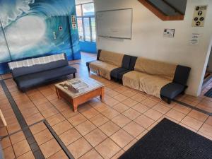 a living room with a couch and a coffee table at Jetty Blue Backpackers in Coffs Harbour