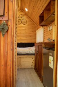 eine kleine Küche mit einem Bett in einer Holzhütte in der Unterkunft Tiny House Remanso del Espíritu in Isla de Maipo