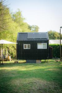 伊斯拉德邁波的住宿－Tiny House Remanso del Espíritu，一座黑色房子,上面有太阳能电池板