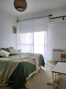 1 dormitorio con cama y ventana grande en Mollinedo home en Salta