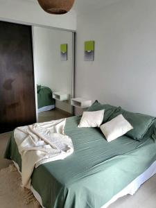 1 dormitorio con 1 cama verde grande y 2 almohadas en Mollinedo home en Salta
