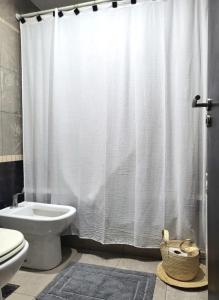 y baño con cortina de ducha y aseo. en Mollinedo home en Salta