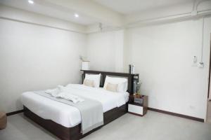 - une chambre avec un grand lit et des draps blancs dans l'établissement ATC Residence, à Bang Su