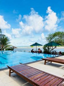 a swimming pool with a view of the ocean at Bay Beach Hotel in Nilaveli