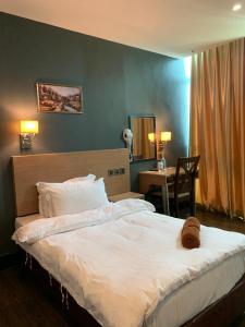 ein Schlafzimmer mit einem Bett mit einem Teddybär drauf in der Unterkunft The Room Hotel in Miri