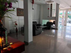 a living room with couches and chairs in a building at The Room Hotel in Miri